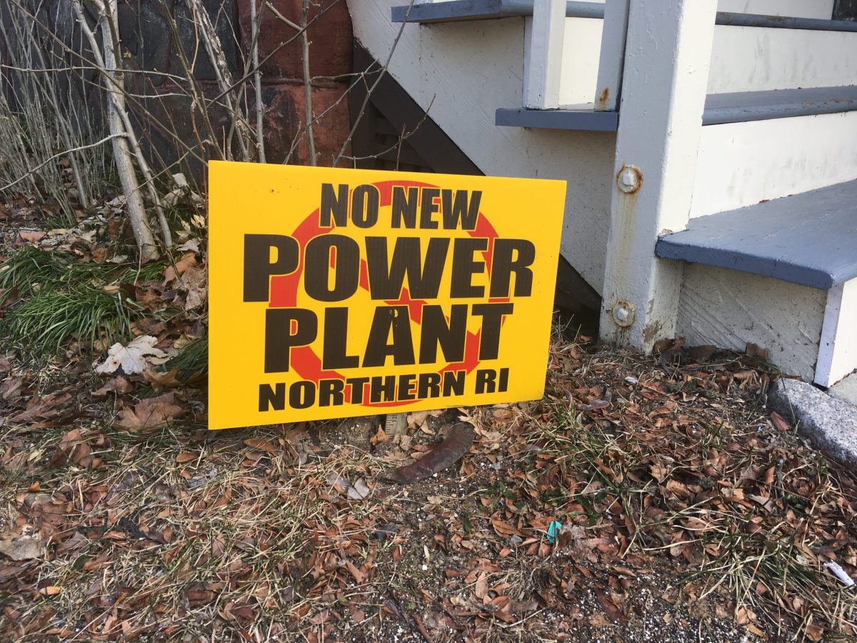 An anti-power plant sign is displayed in the front yard of a property in Providence.