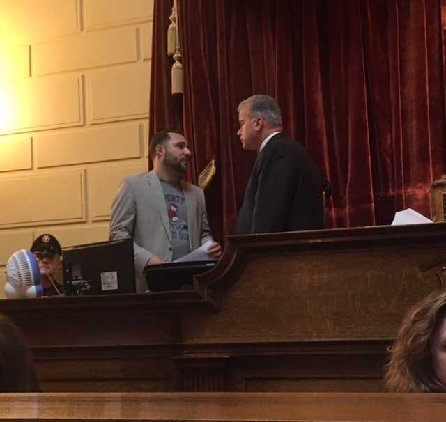 State Rep. Carlos Tobon (D-Pawtucket), wearing a PawSox shirt, talks with House Speaker Nicholas Mattiello on Thursday.