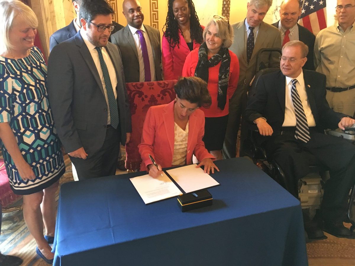 Governor Gina Raimondo signs an executive order last September appointing Shaun O'Rourke (left to the governor) as the state's first-ever cheif resiliency officer. O'Rourke was tasked with developing a statewide plan for preparing for climate change.