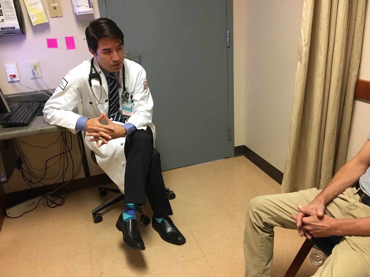 Dr. Joseph Garland, medical director of The Miriam Hospital's Immunology Center, talks with a patient at the STD clinic in September 2017.