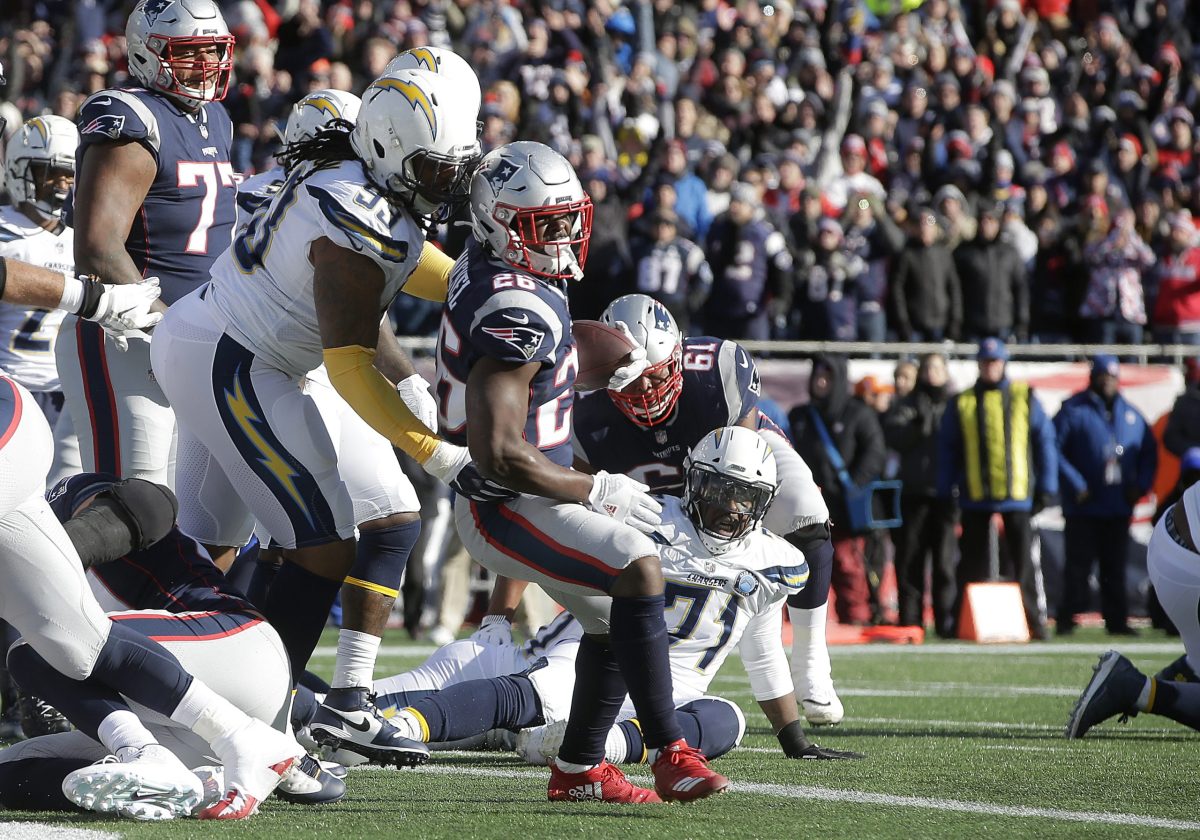 New England Patriots running back Sony Michel (26) scores a touchdown in front of Los Angeles Chargers defensive tackle Darius Philon (93) during the first half of an NFL divisional playoff football game, Sunday, Jan. 13, 2019, in Foxborough, Mass.