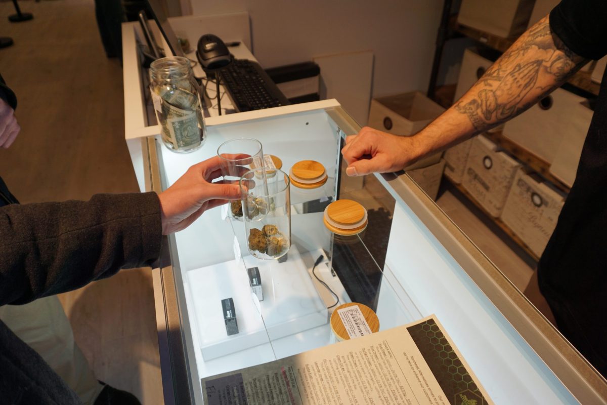 A customer smells samples with a 'bud tender' at Northeast Alternatives in Fall River.