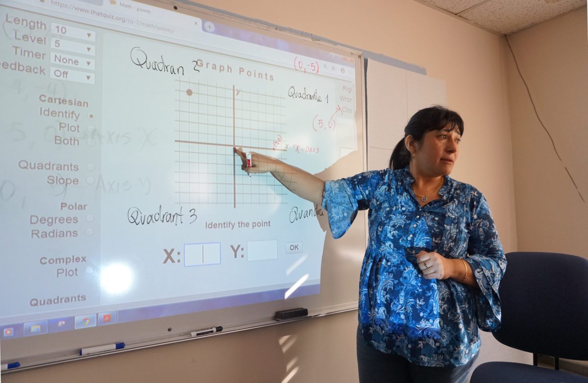 GED prep class teacher Esther Avecedo points to a lesson at Progreso Latino, in Central Falls