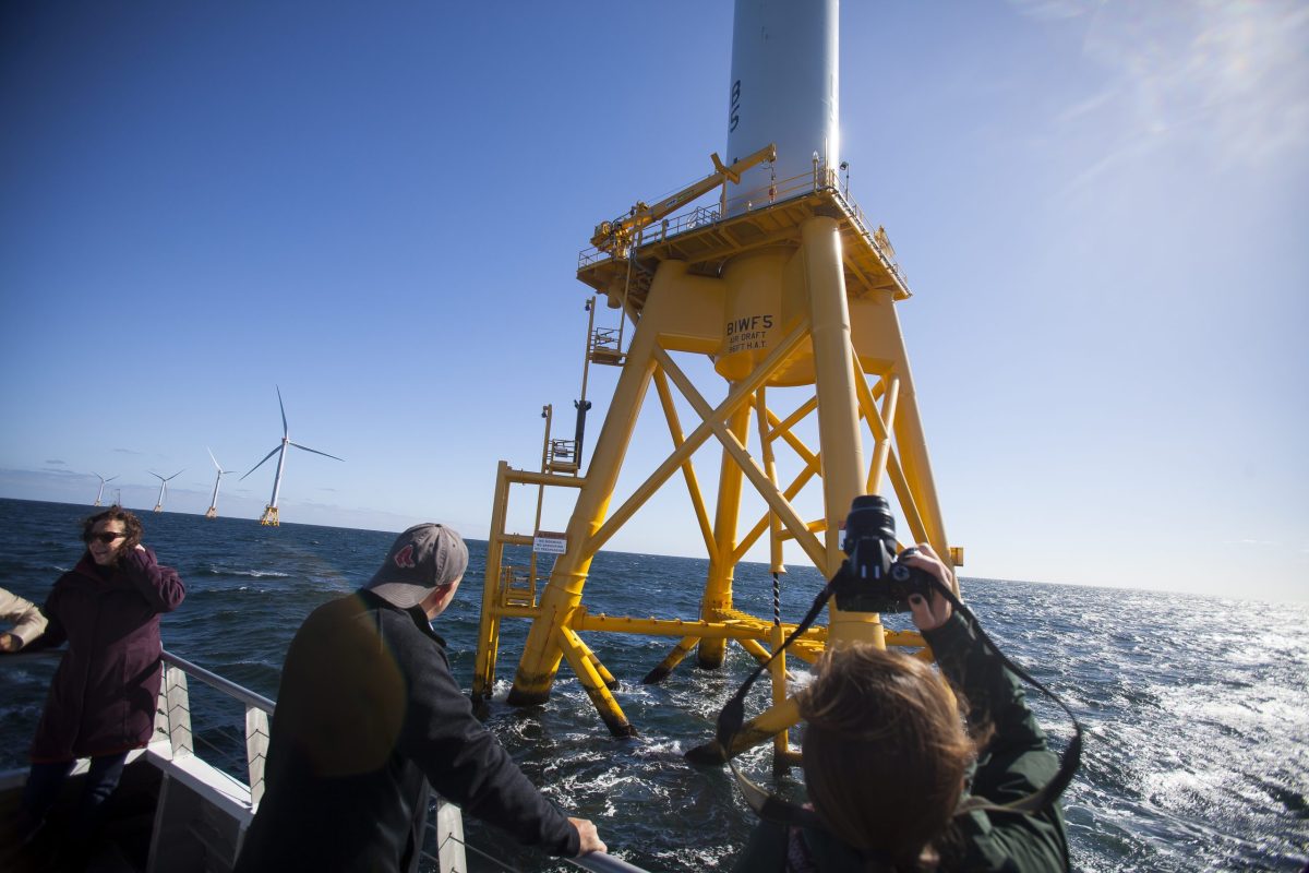 People on the National Wildlife Federation tour of the Block Island Wind Project take pictures of the turbines