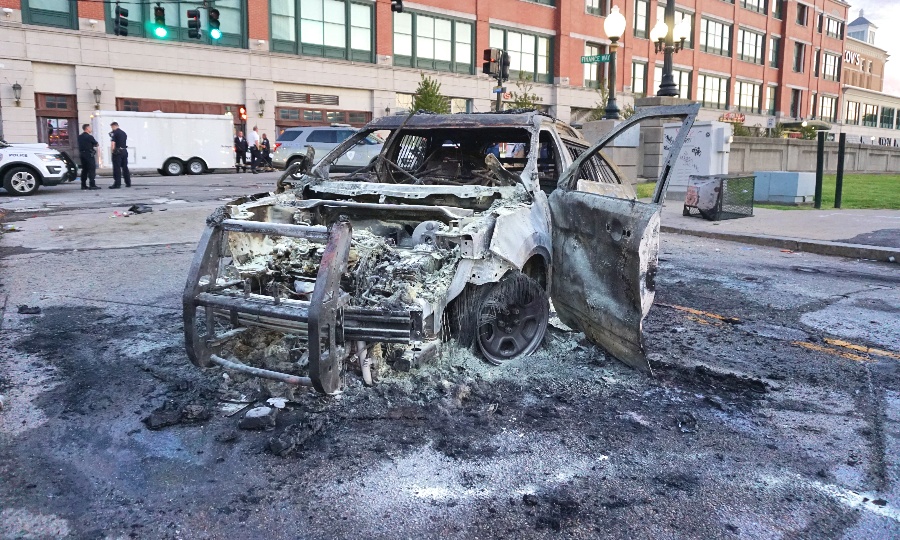 The remains of a police cruiser set on fire by rioters near the Providence Place Mall