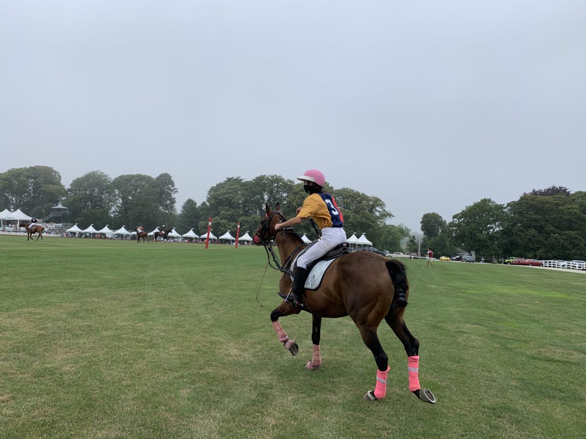 A player on the Astors team rides onto the polo field.