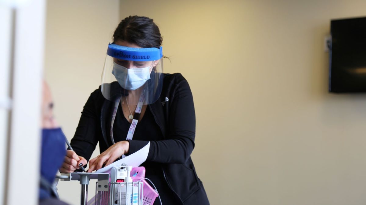 Natasha Viveiros, RN, works to vaccinate a patient at the Chafee Health Center in Providence.