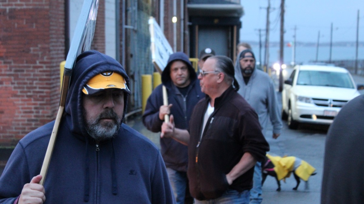 Union members hold up replacement workers leaving the ATI plant in New Bedford.