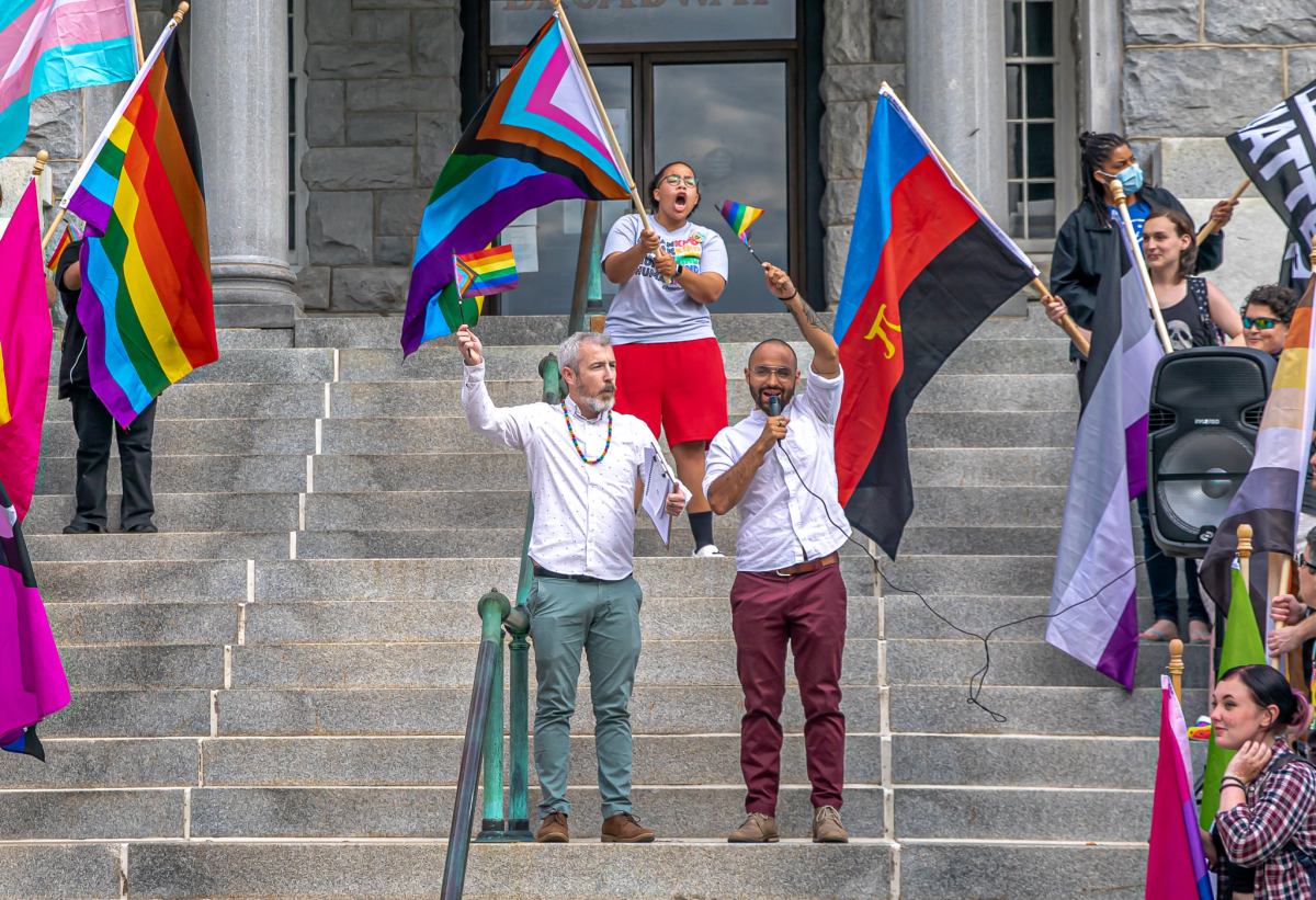 Sean O'Connor (left) and Daniel Cano Restrepo speak at a flag raising event at Newport City Hall.