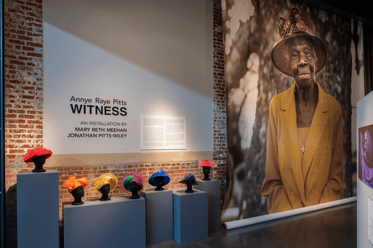 Witness gallery with church hats and portrait of Annye Raye Pitts (photo by Elaine Fredrick)