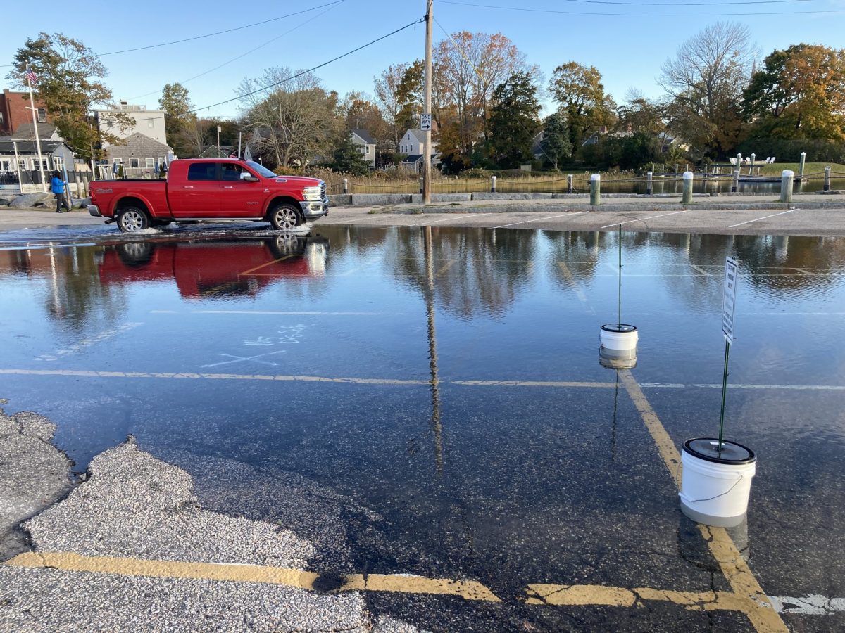 A truck drives through Wickford's Brown Street parking lot during high tide November 5, 2021.