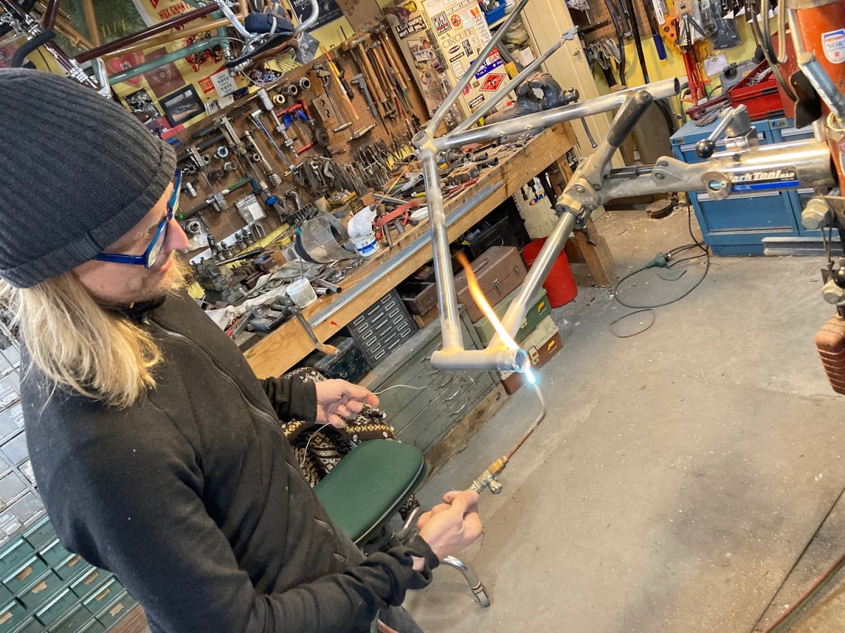 Brian brazes the juncture between tubes on a custom bicycle frame