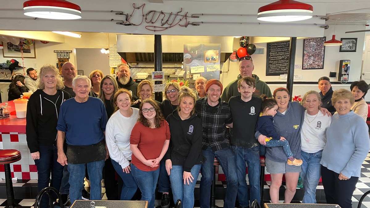 Gary Hooks, second from left, and his wife, Mary, far right, pose for a group portrait with family and friends after their diner, Gary's Handy Lunch closed its doors for the last time on Feb. 12, 2023. Gary's Handy lunch was a beloved diner in downtown Newport.
