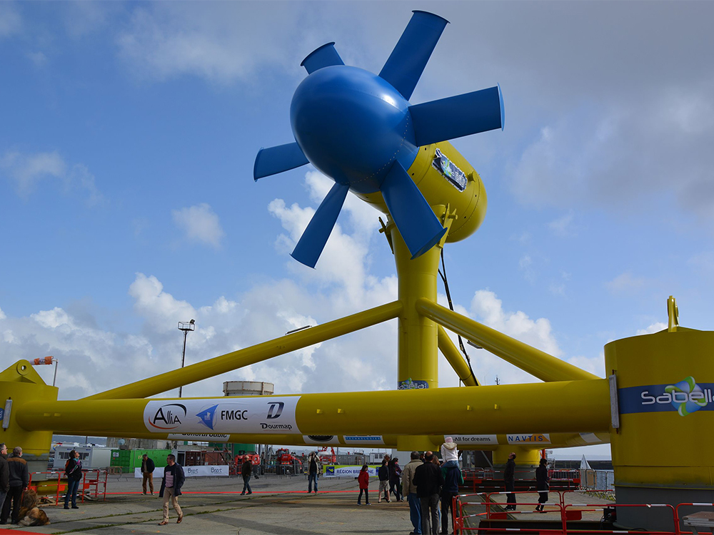 A yellow and blue tidal turbine on a dock