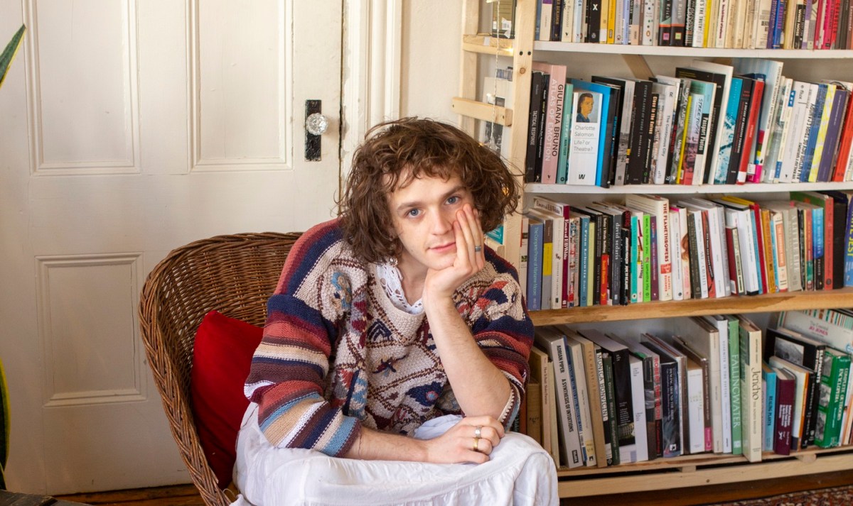 musician Asher White sitting on a red chair
