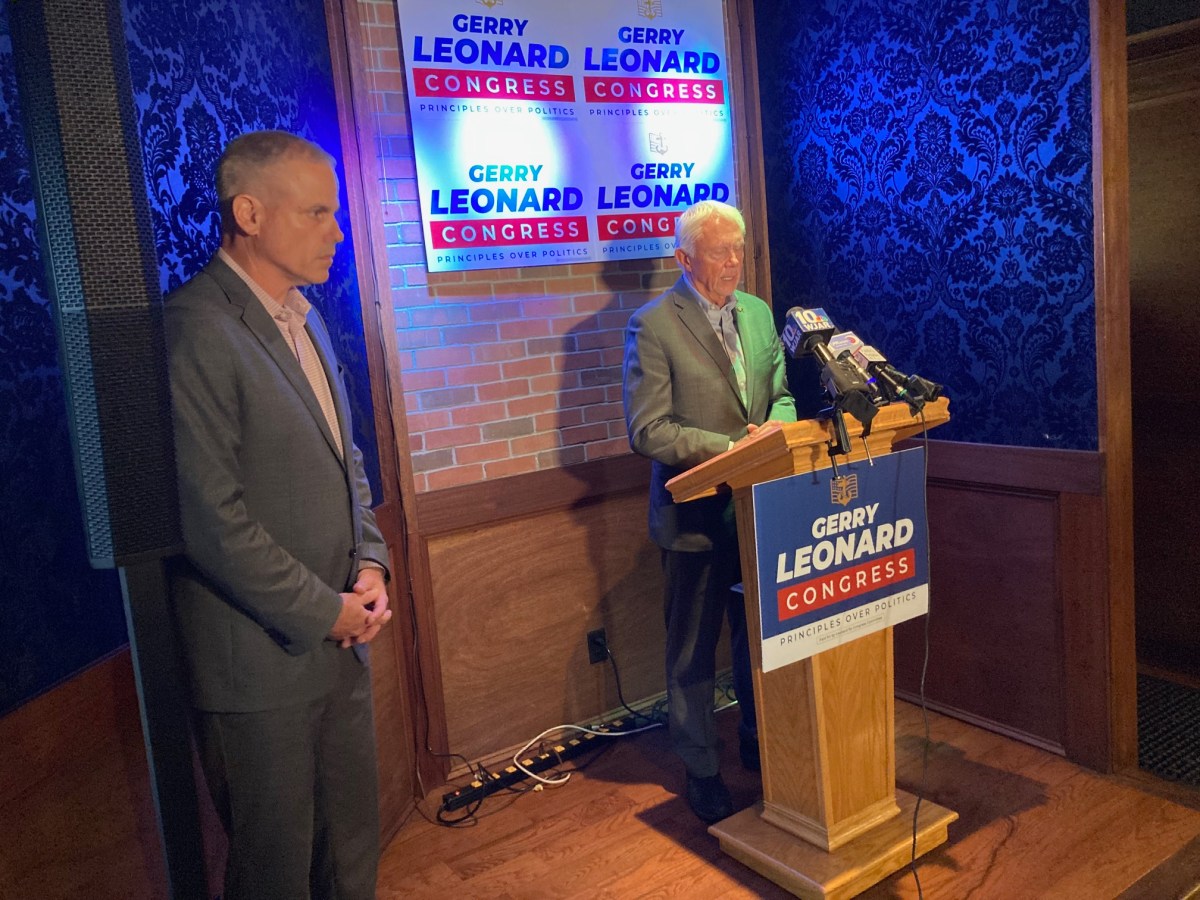 Leonard looks on as Bergman speaks at the podium