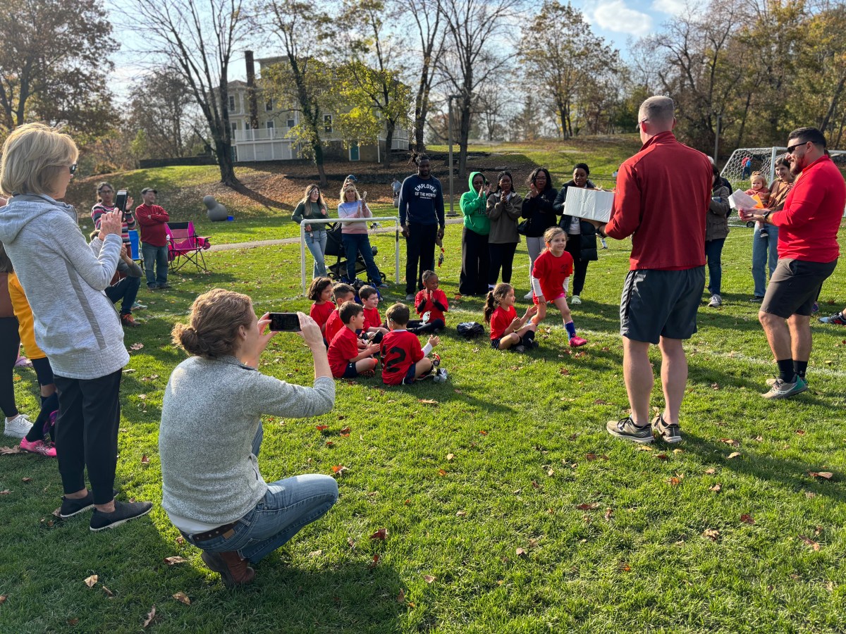 Coaches Mike Parkin and Pat McNally present little trophies to their little Huskies at the end of another East Side Sports soccer season.