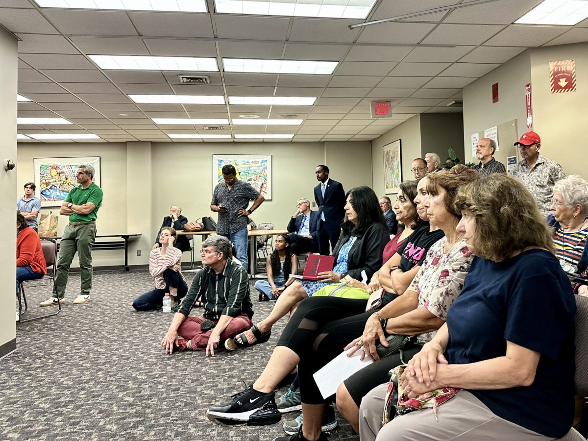 So many people showed up to the meeting that some had to sit on the floor or stand, like Fox Point city council representative John Goncalves.
