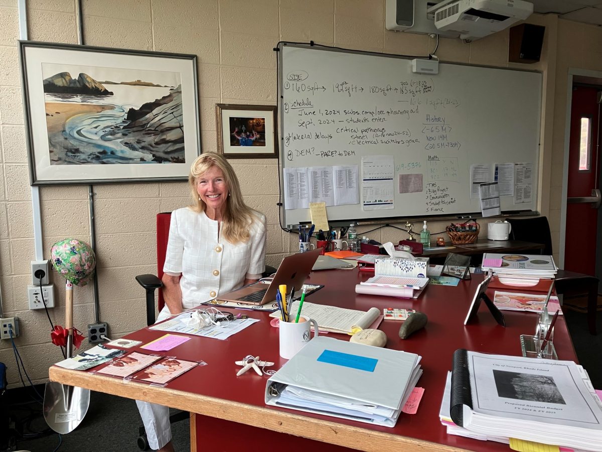 Superintendent of Newport Public Schools Dr. Colleen Burns Germain poses for a portrait in her temporary office at Rogers High School in Newport on Friday, Aug. 25, 2023. Her ceremonial construction hat and shovel lean against the wall behind her.