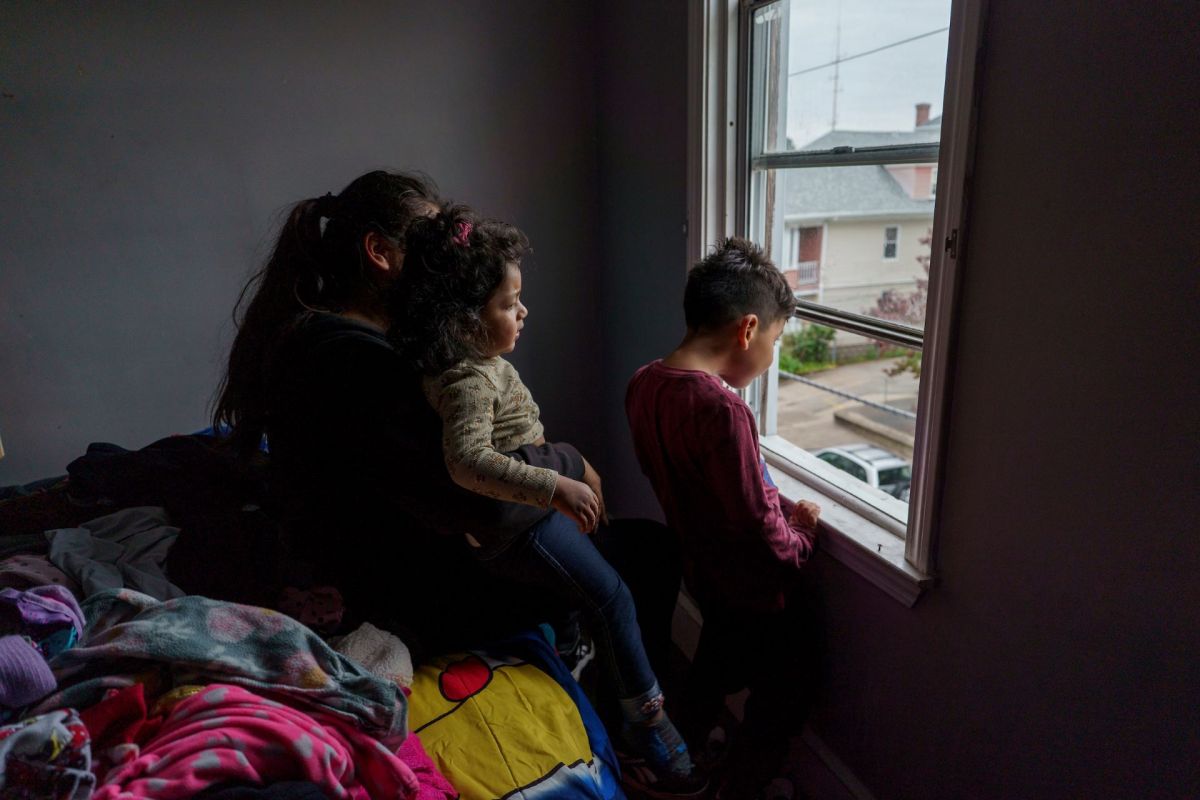 Marisa and her two kids sit by her bedroom window on October 18th, 2023. Two months prior, she learned her two-year-old had elevated levels of lead in her blood. She is still waiting for the landlord to make repairs.