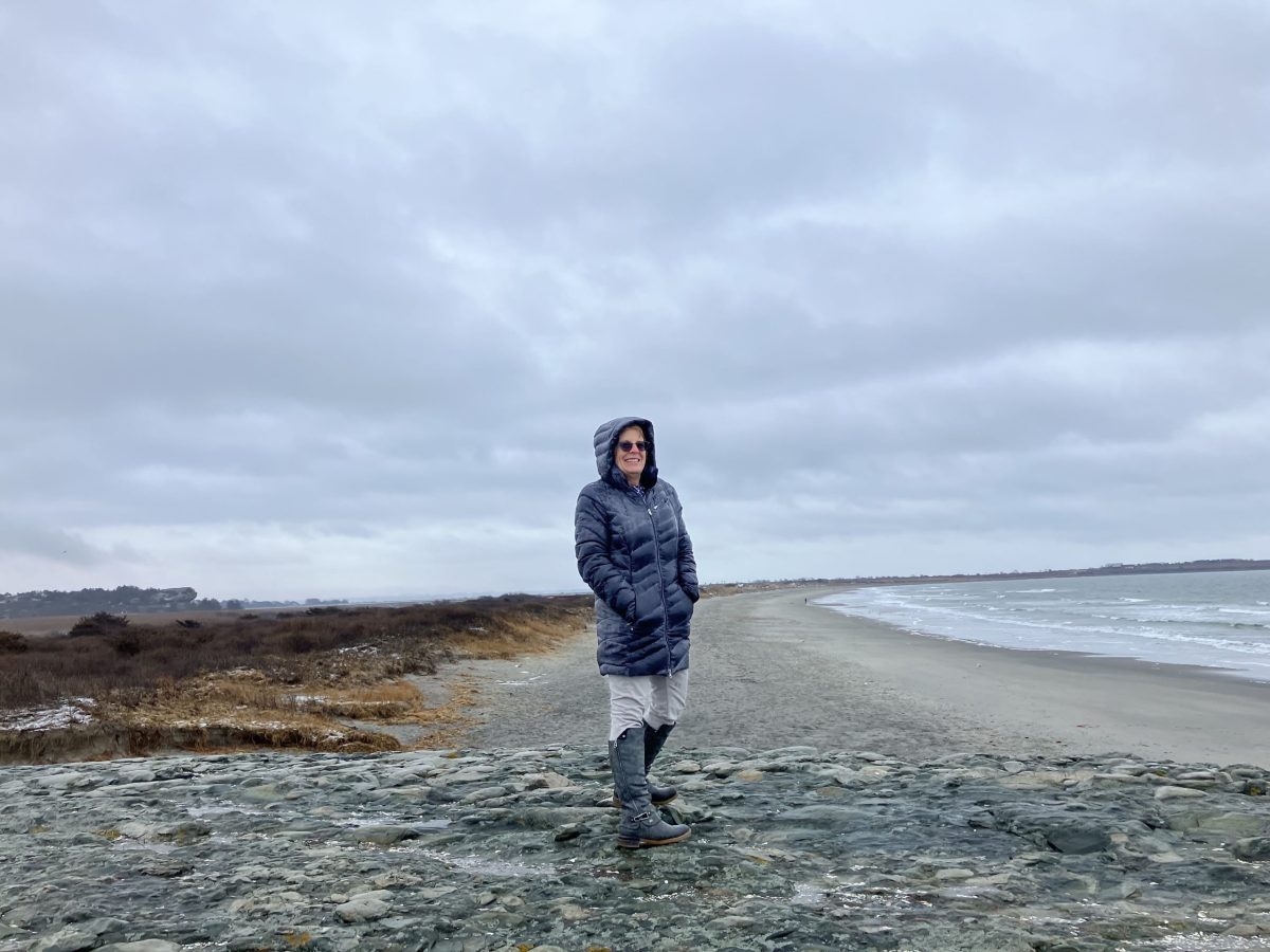 State Representative Terri Cortvriend stands on a rock at Surfers End at Sachusest Beach in Middletown, on Wednesday, Jan. 24, 2024. In every directions, she can see the effects of climate change in her district.