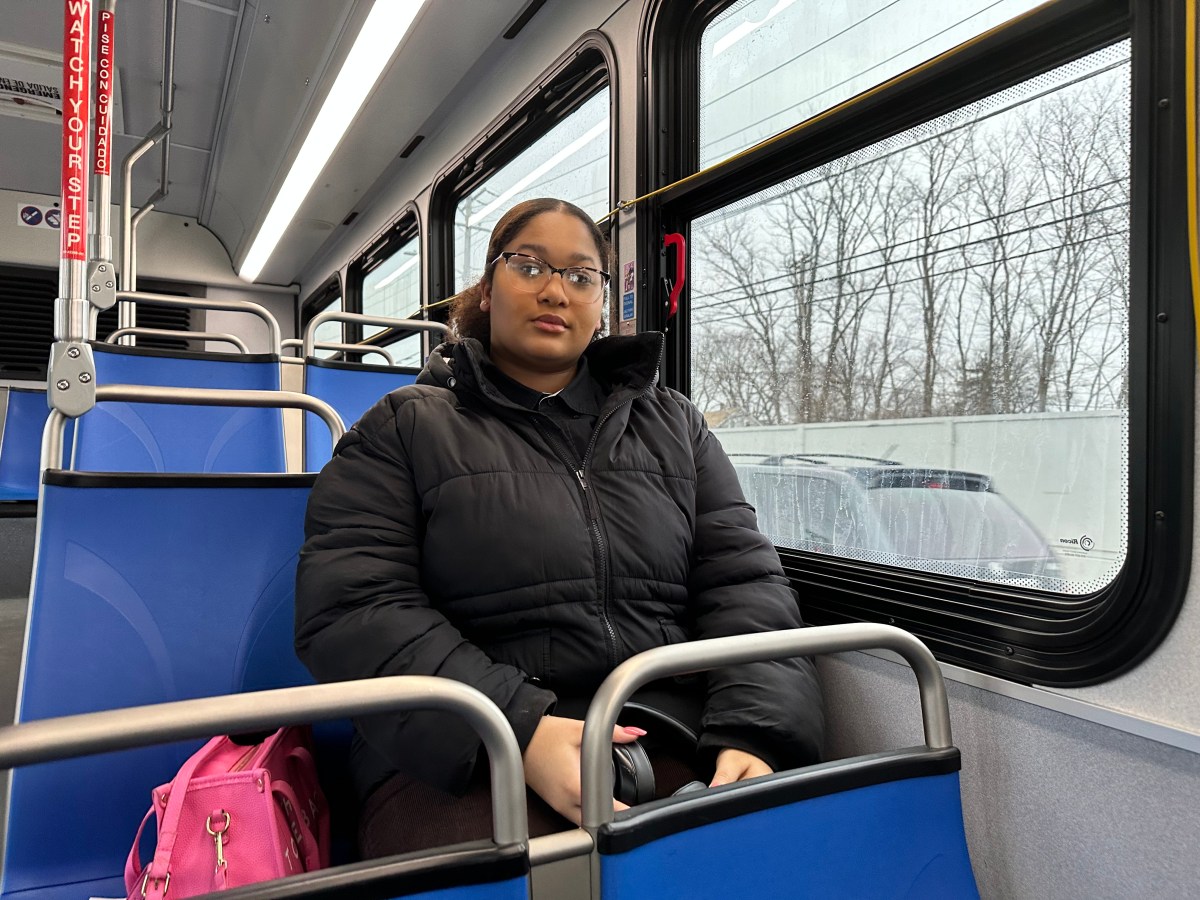 A woman sits inside an empty bus
