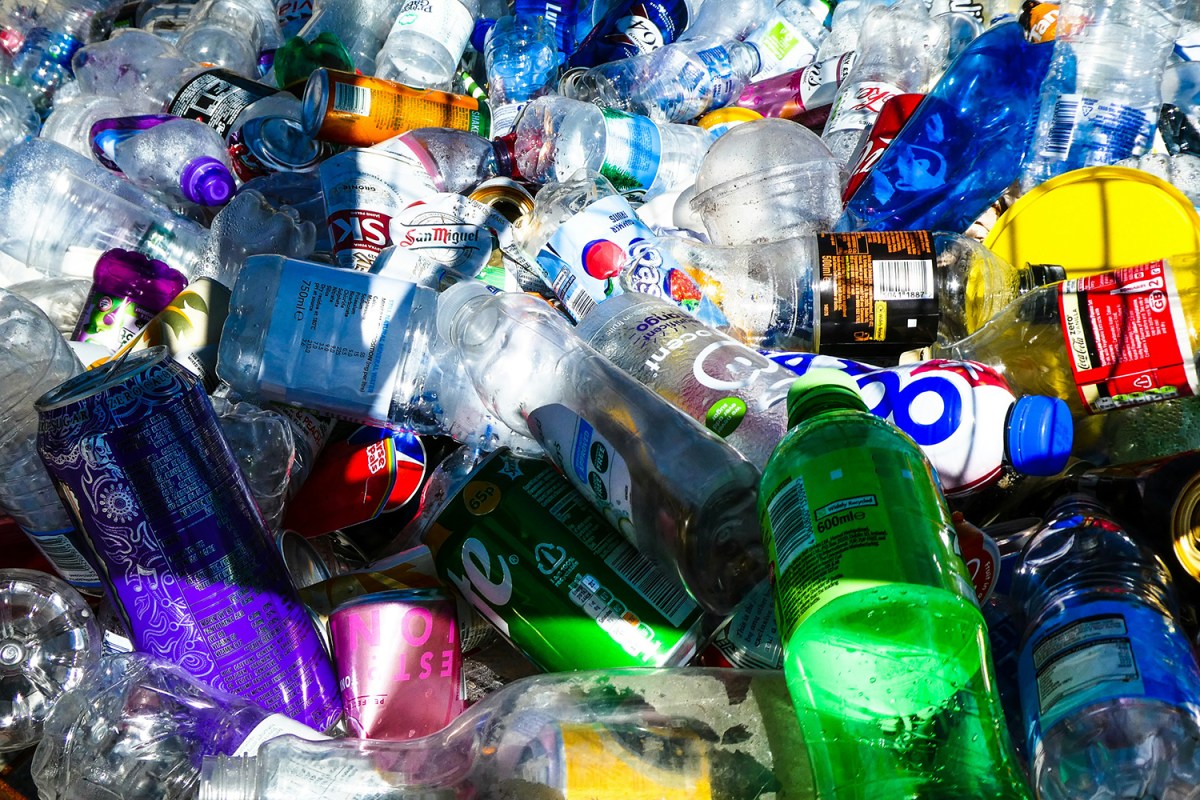 A pile of brightly colored soda bottles, dishwasher detergent, and aluminum cans set to be recycled.