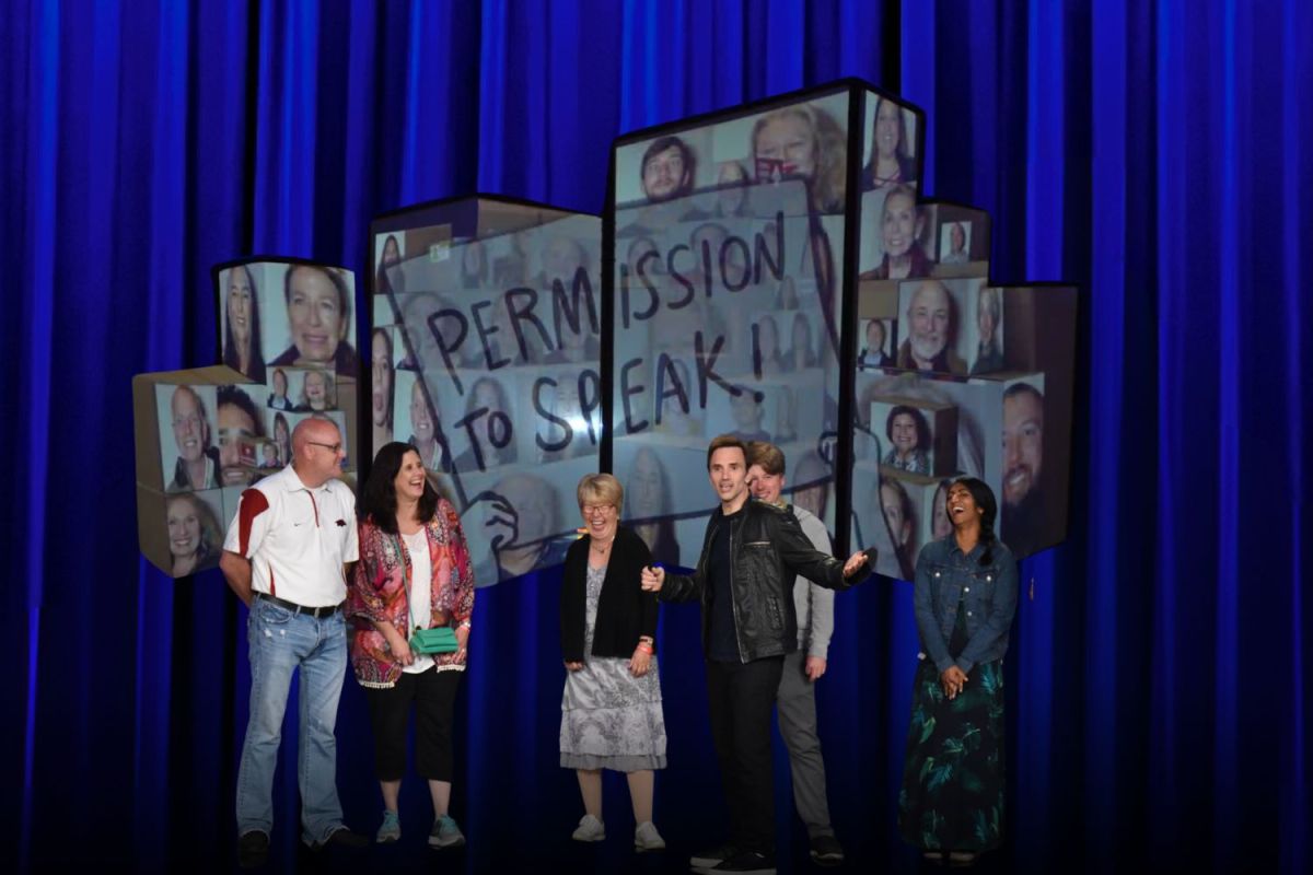 Comedian Paul Mecurio on stage with audience members. Blue background with collage of headshot photos of audience members