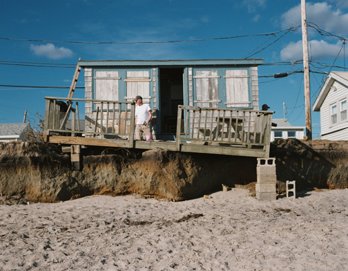 A photograph captures damage to shoreline homes at Roy Carpenter’s Beach in South Kingstown.