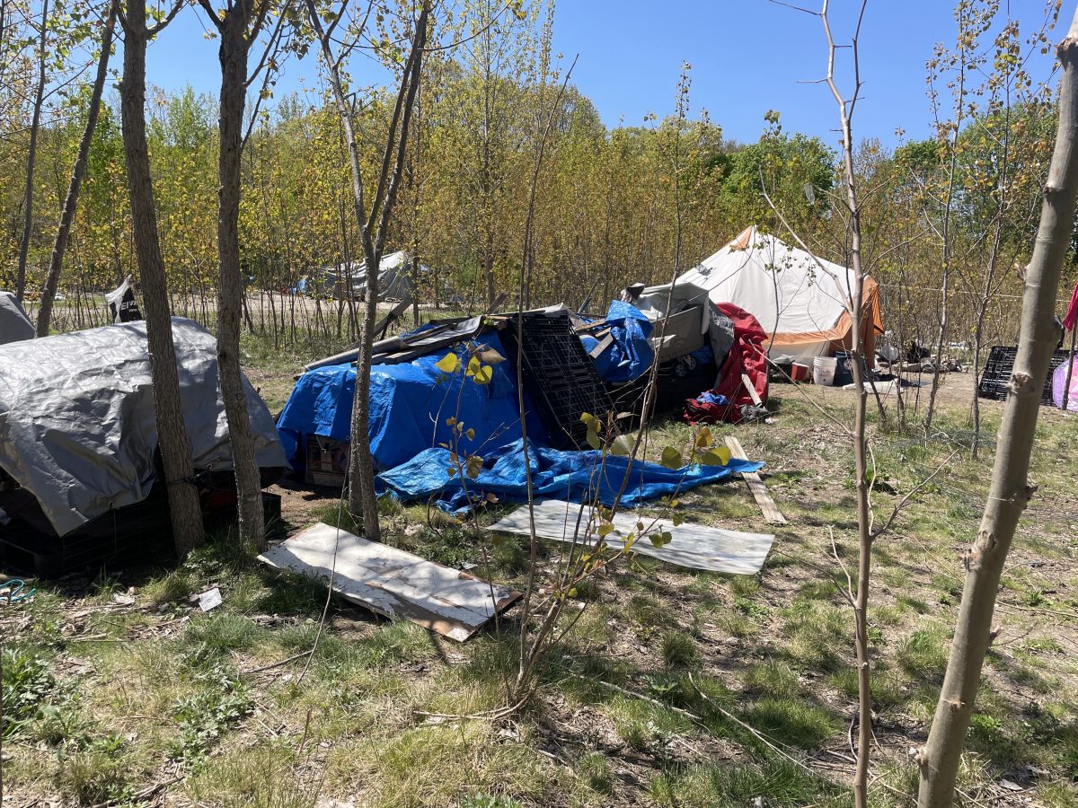 Tarps cover an electric generator and spare supplies at an encampment in Providence. The white tent in the background serves as a community kitchen, complete with canned goods and a microwave.