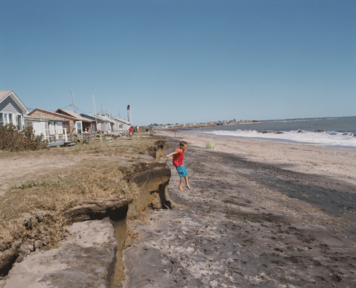 A photograph captures damage to shoreline homes at Roy Carpenter’s Beach in South Kingstown.