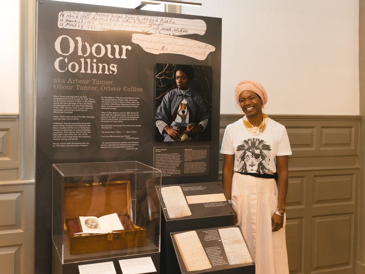 Artist Cat Laine with her portrait of Obour Collins, titled "Obour’s Anamnesis."