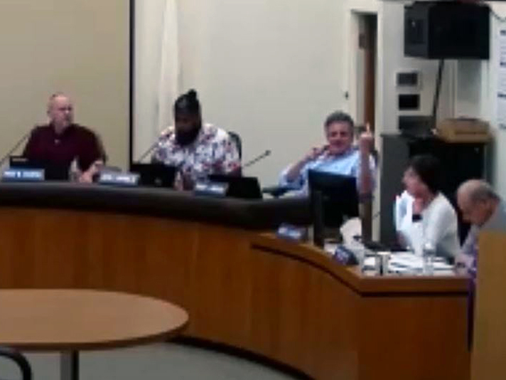 Westerly Town Council member Robert Lombardo sticks up his middle finger at a meeting Monday night.