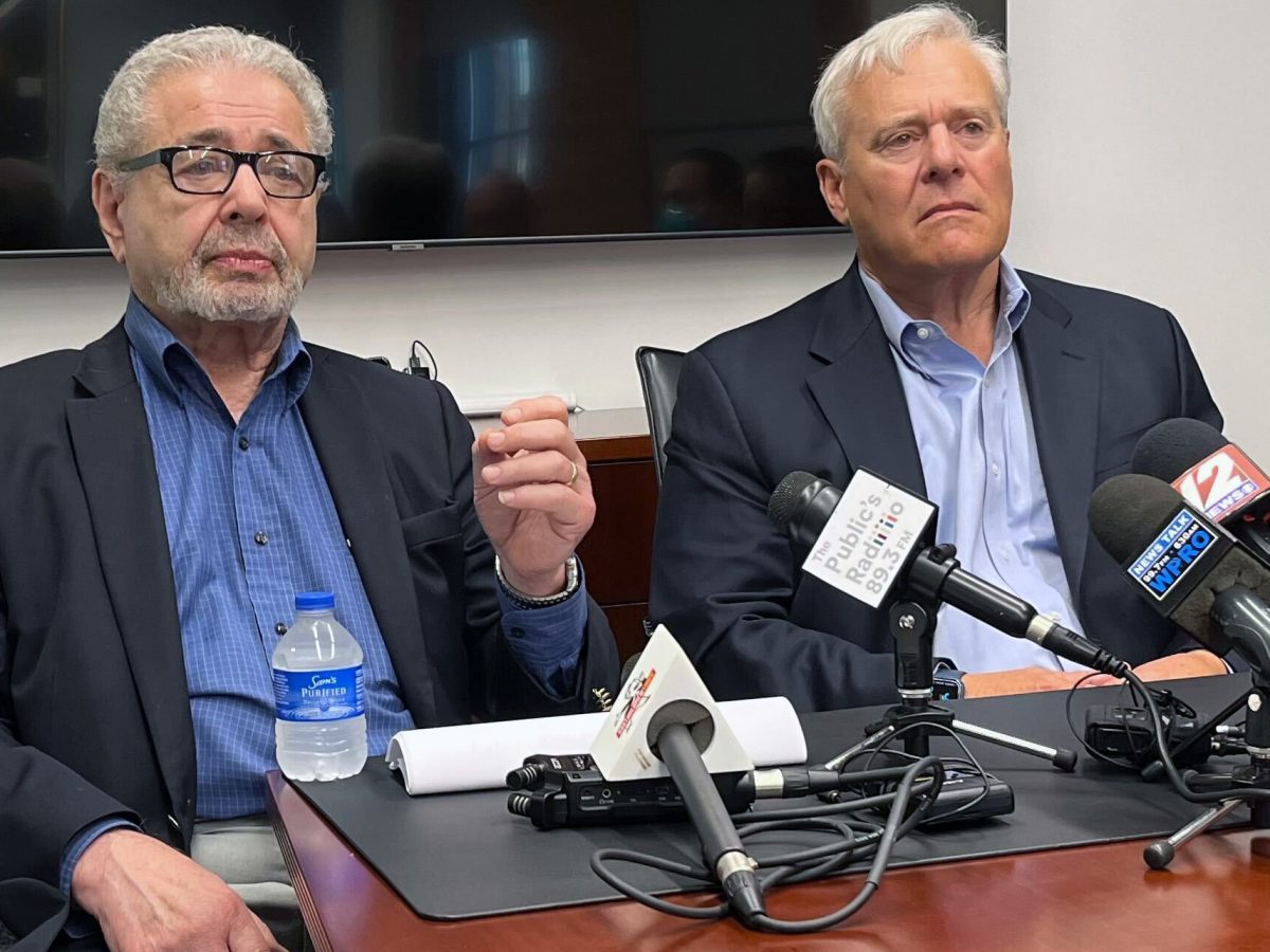 Lawyers Max Wistow, left, and Jonathan Savage speak with reporters at a conference room table.